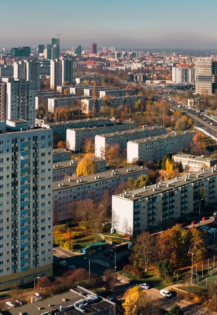 Aerial view of residential buildings in Poznań, Poland, showcasing autumn colors and urban landscape.
